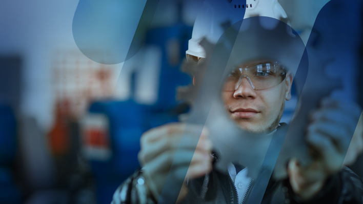 ingeniero con casco mirando por un engranaje