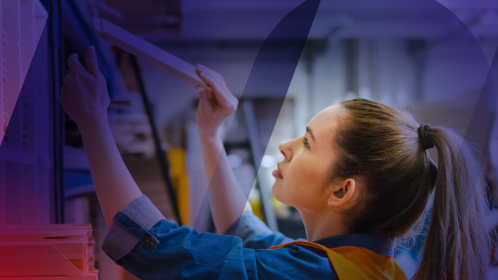 Una joven trabajadora acomodando productos en un estante del almacén